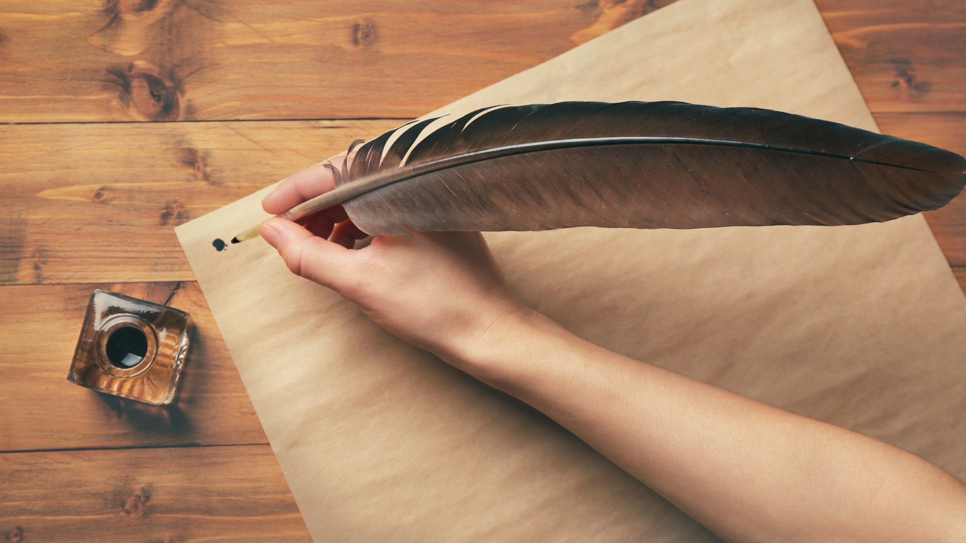 Main écrivant à la plume sur une feuille posée sur une table en bois – illustration douce pour textes d’amour sincères